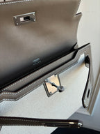 Close-up of Hermes bag interior with toggle clasp, stitching, and logo panel