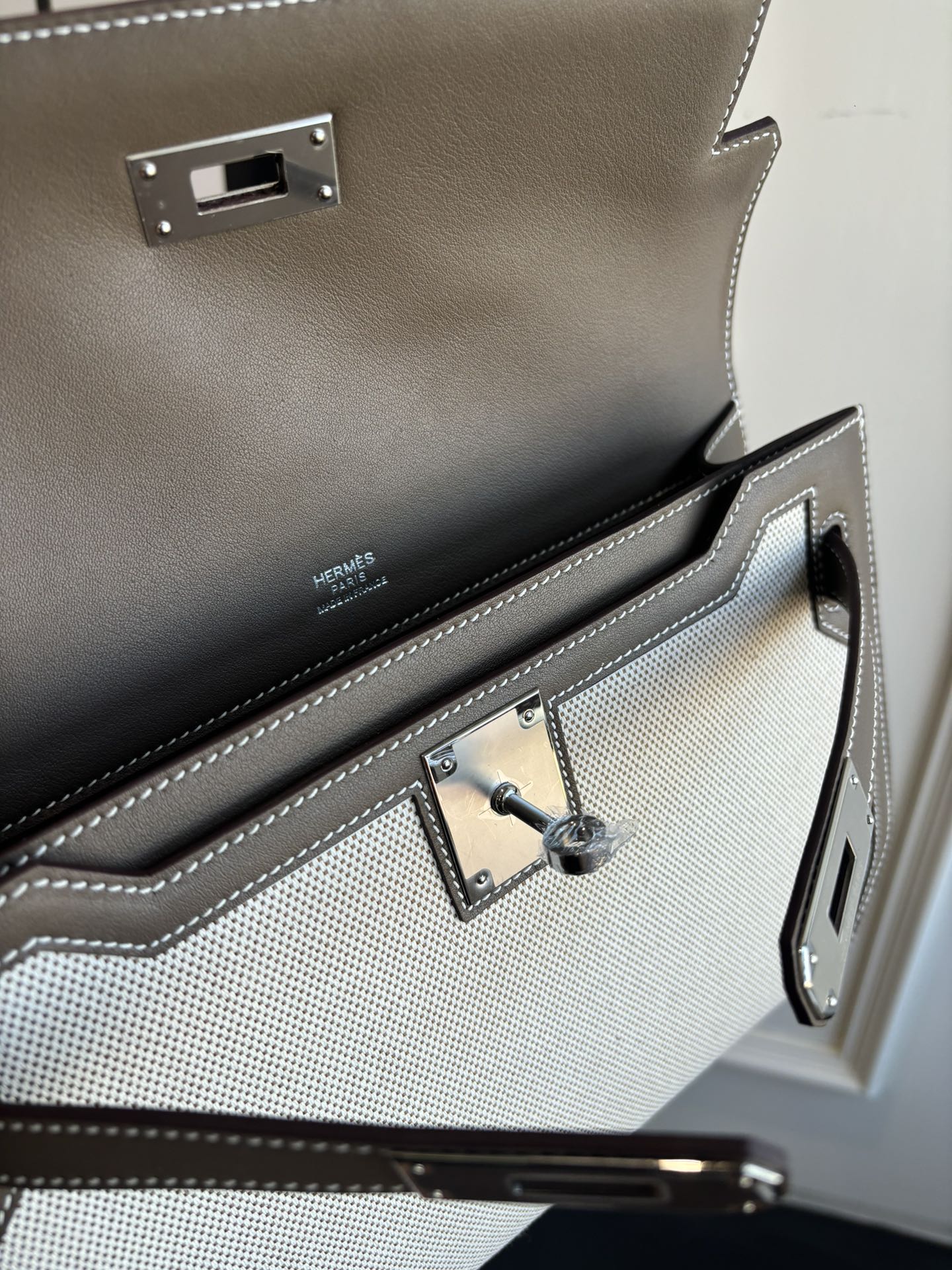 Close-up of Hermes bag interior with toggle clasp, stitching, and logo panel