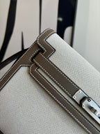 Close-up of beige textured Hermes bag front strap with buckle and stitched trim