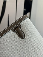 Beige textured Hermes bag front flap tab with stitched leather detail
