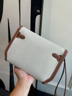 Hermes crossbody bag front view, light canvas body with brown leather flap and strap