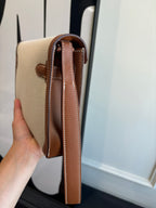 Hermes bag back view, light canvas with brown leather side straps and handle loop