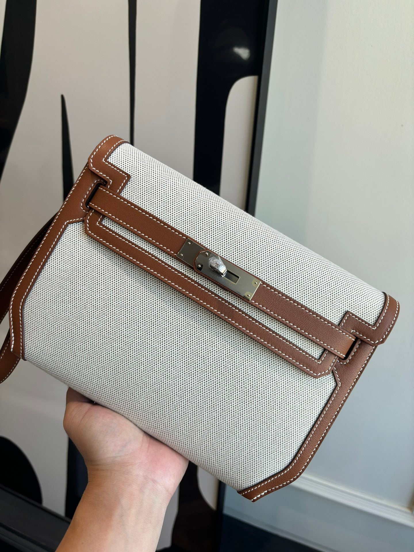 Hermes bag in light canvas with brown leather trim, front flap and buckle closure