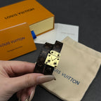 Louis Vuitton monogram leather bracelet with gold-tone buckle clasp, held in hand.