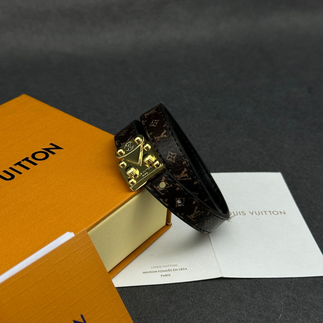 Louis Vuitton monogram leather bracelet with gold-tone buckle clasp, angled.