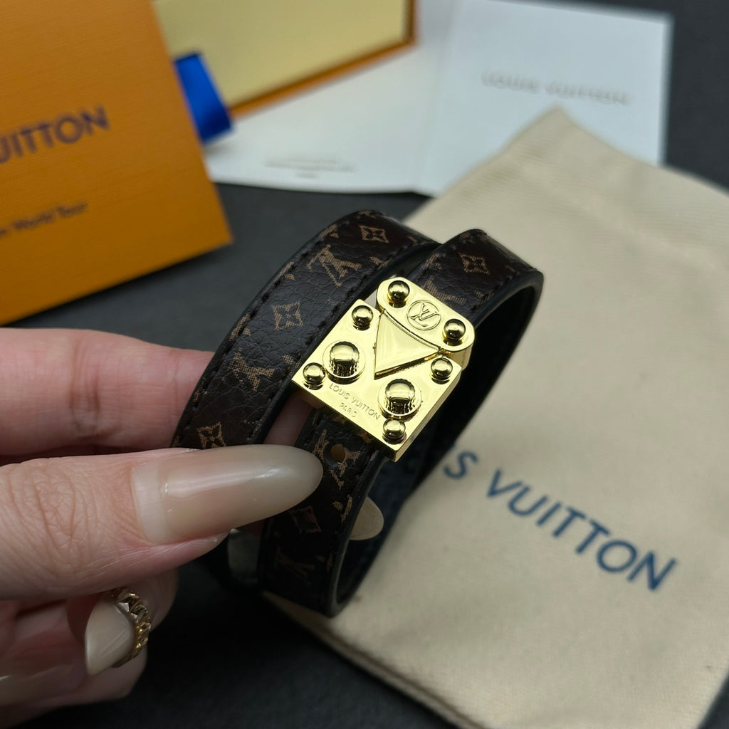 Louis Vuitton monogram leather bracelet with gold-tone buckle clasp, side view.