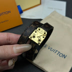 Louis Vuitton monogram leather bracelet with gold-tone buckle clasp, side view.