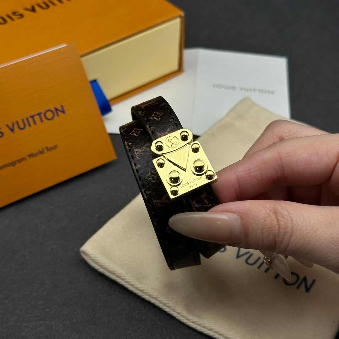 Louis Vuitton monogram leather bracelet close-up with gold-tone buckle clasp.