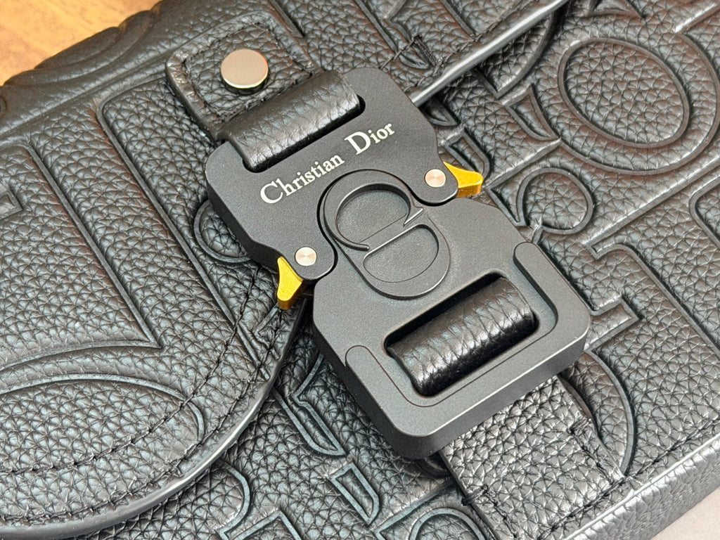 Embossed dark leather Dior bag corner with metal charm and 'Christian Dior' tag