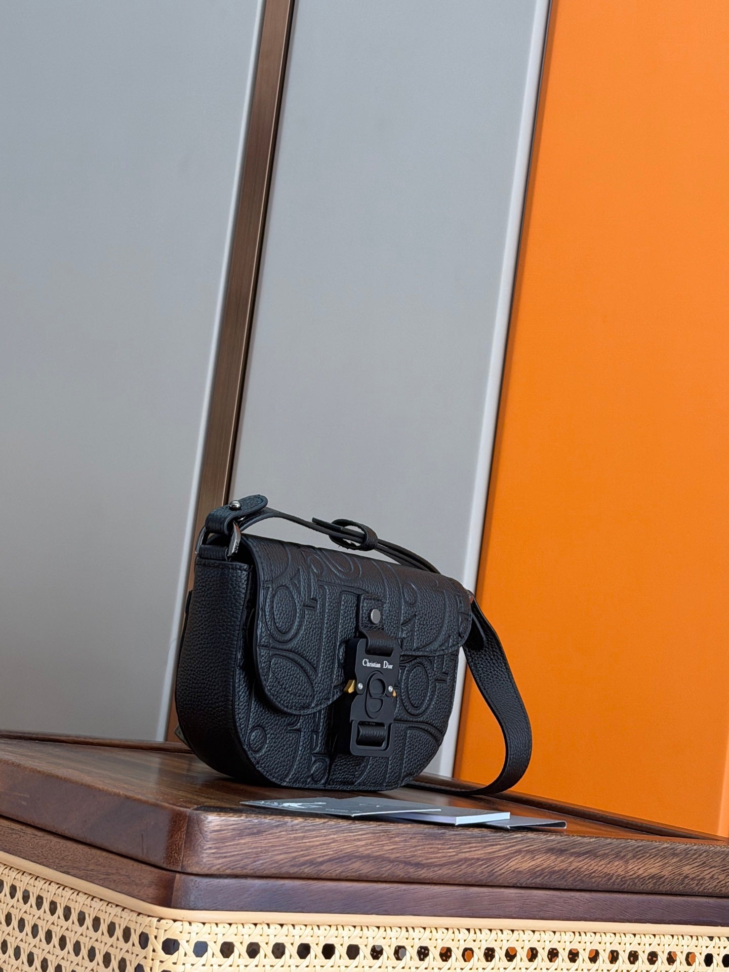 Small dark crossbody bag with flap closure and adjustable shoulder strap
