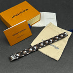 Louis Vuitton monogram strap with silver end hardware, resting on cream dust pouch