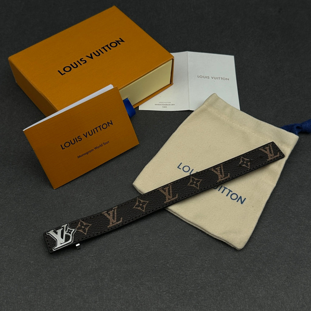 Louis Vuitton monogram strap with blue bow tie, beside cream dust pouch
