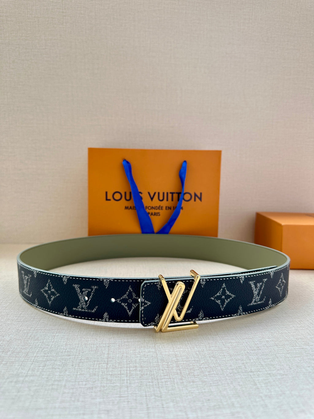 Louis Vuitton belt in dark navy monogram canvas with gold-tone V buckle.