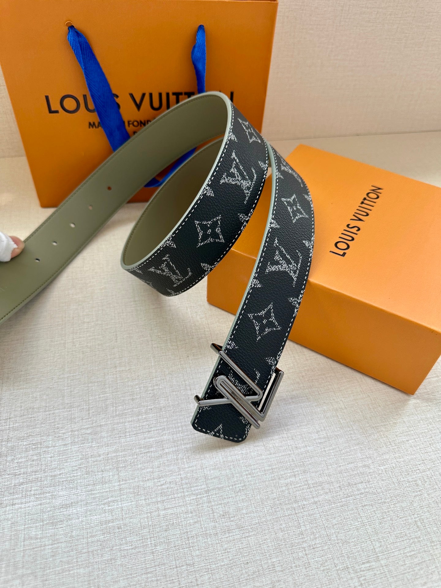 Louis Vuitton dark navy monogram belt with gold-tone buckle, visible stitching.