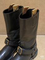 Dark brown leather mid-calf boots with side tab and double buckle straps.