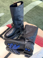 Dark navy leather mid-calf boots with buckled straps and patterned outsole.