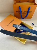 Blue leather belt with gold buckle and embossed leather, in an open gift box