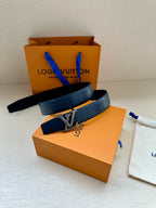 Blue leather belt with gold buckle, laid across the gift boxes