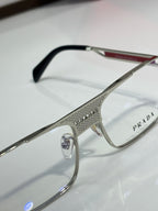 Prada eyeglasses close-up: silver frame with black temple tips, clear lenses