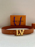 Tan leather belt with perforated strap and gold-toned LV buckle, with shopping bag in background