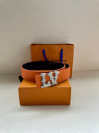 Orange leather belt with silver-tone LV buckle centered on the strap