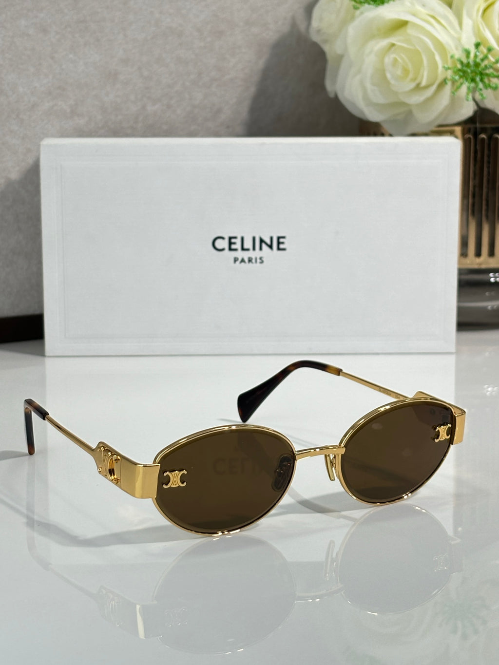 Side-view round sunglasses with gold frame and dark tinted lenses