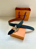 Louis Vuitton belt with dark blue leather and gold LV buckle, laid across box