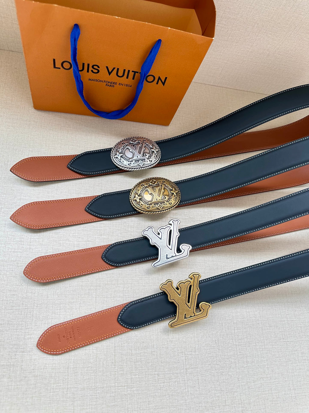 Louis Vuitton belt set with dark blue straps and gold buckle emblems