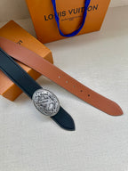 Two leather belt straps: navy and tan, with silver oval logo buckle