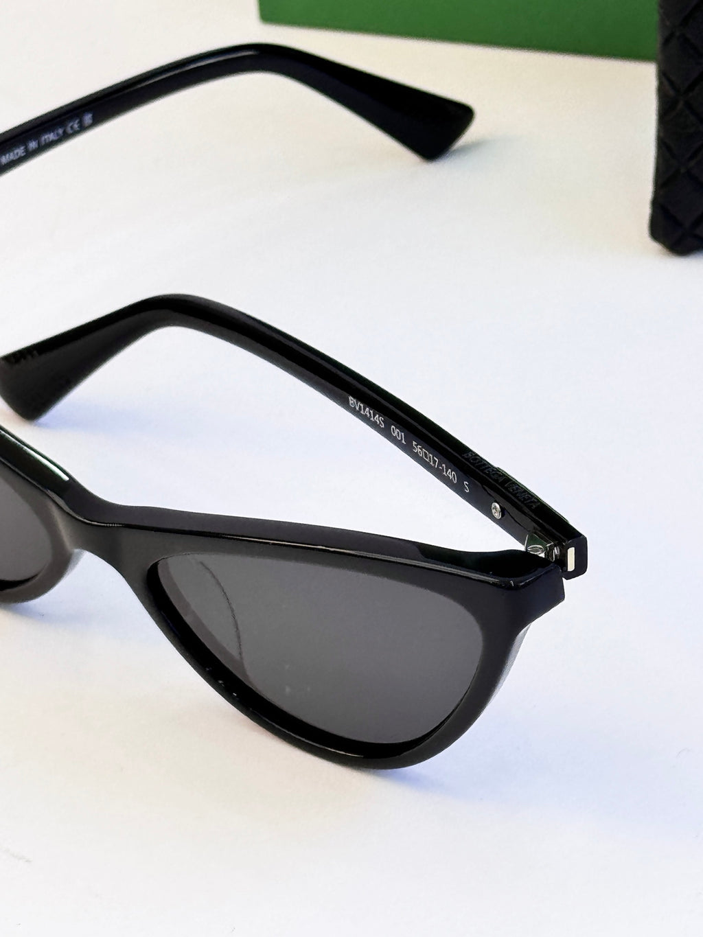 Black cat-eye sunglasses close-up with gold-tone hinge detail