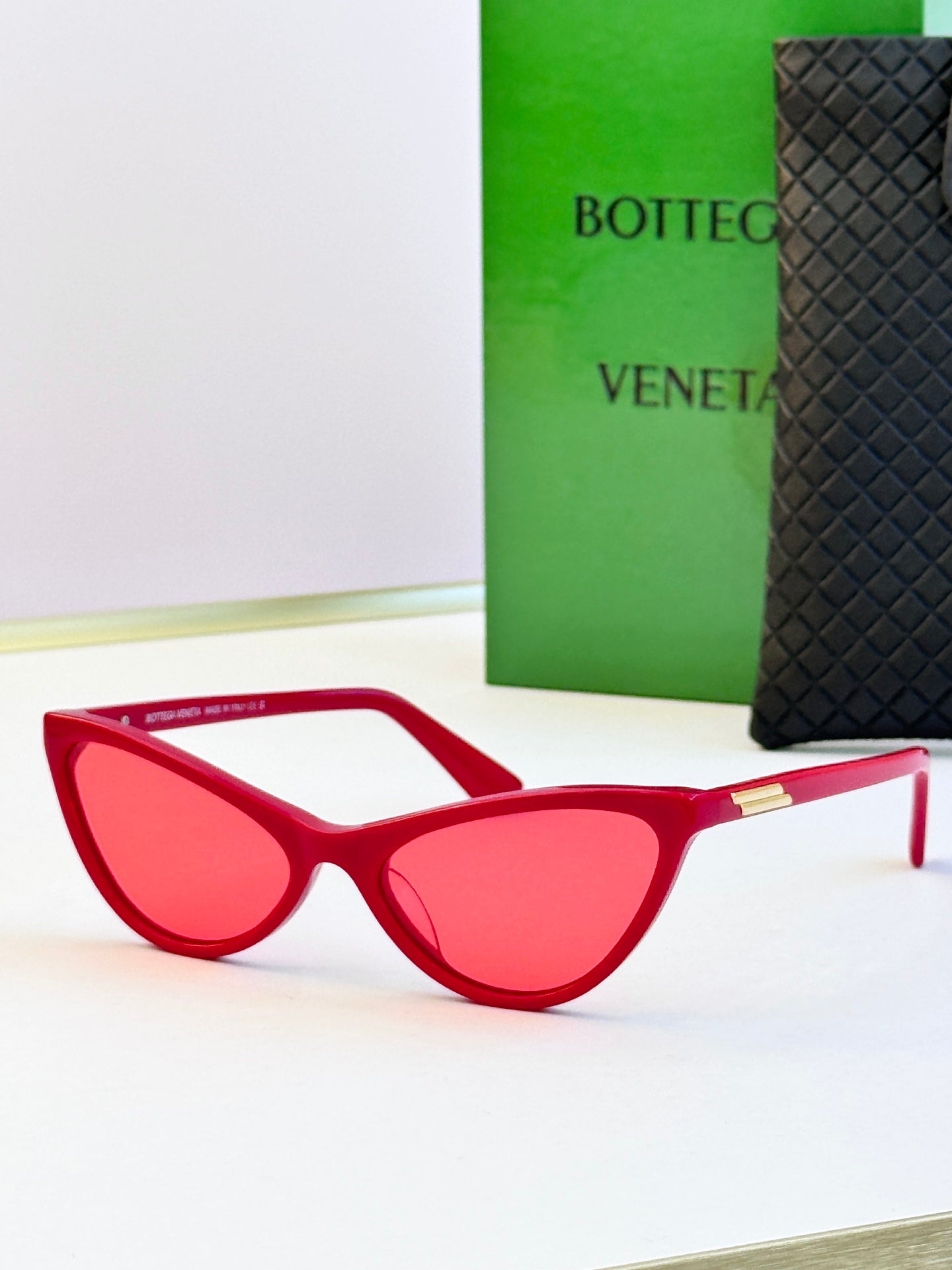 Red cat-eye sunglasses with red lenses and gold-tone temple tips