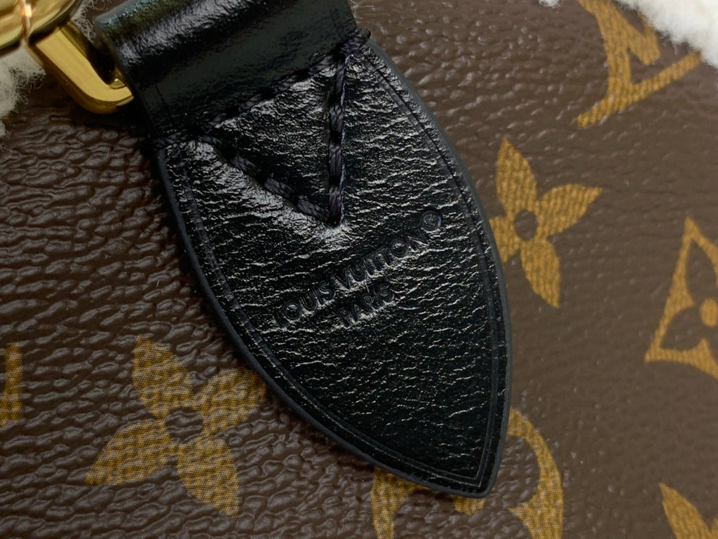 Black leather corner trim on monogram canvas bag with textured finish