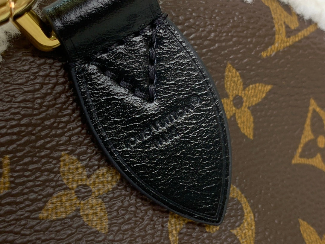 Black leather corner trim on monogram canvas bag with textured finish