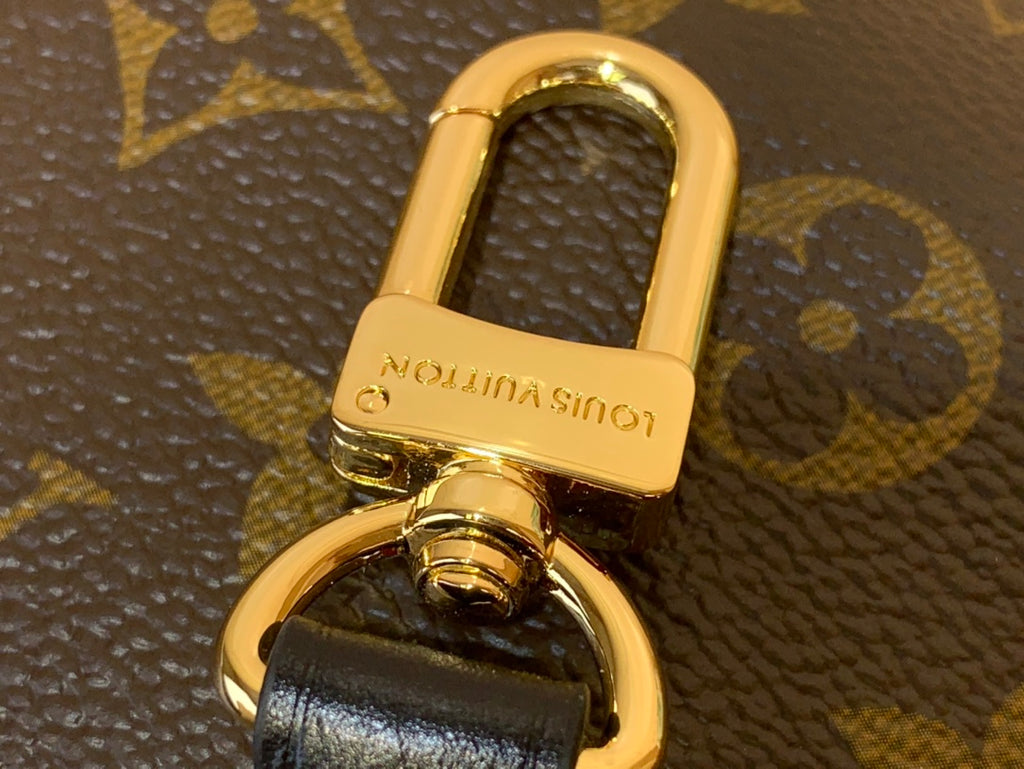 Gold bag clasp with Louis Vuitton imprint on monogram canvas hardware