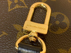 Gold bag clasp with Louis Vuitton imprint on monogram canvas hardware
