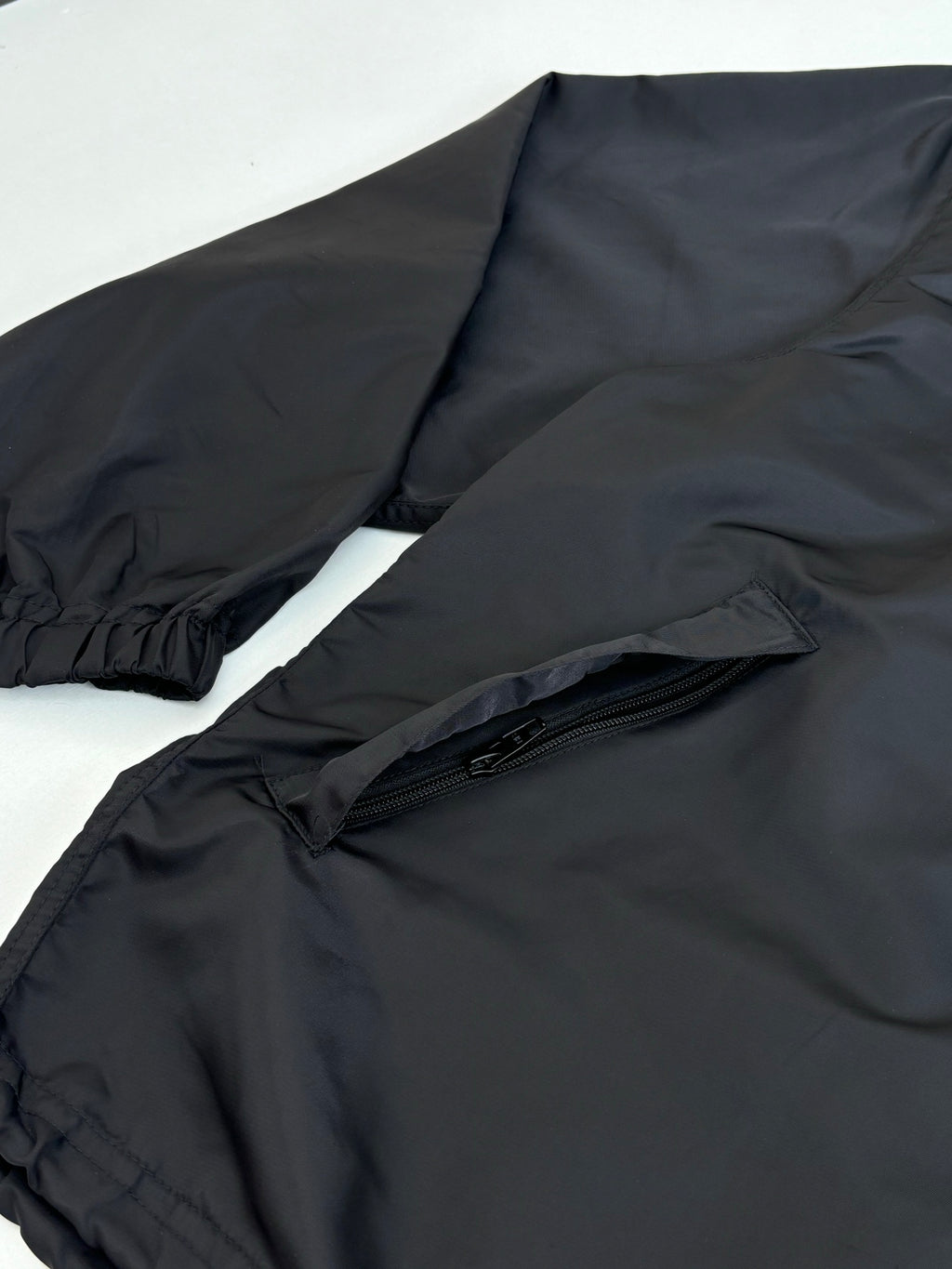 Black parka jacket with elastic cuffs and front zip pocket