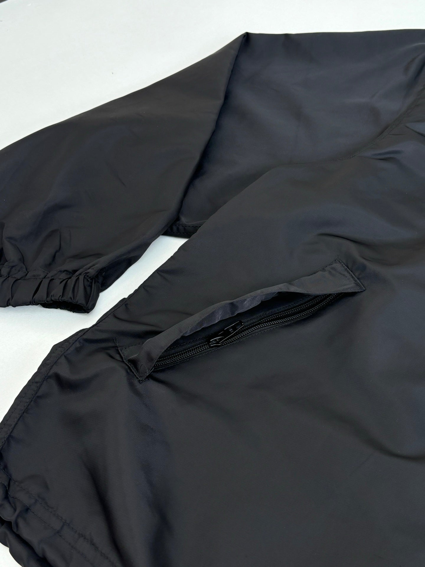 Black parka jacket with elastic cuffs and front zip pocket
