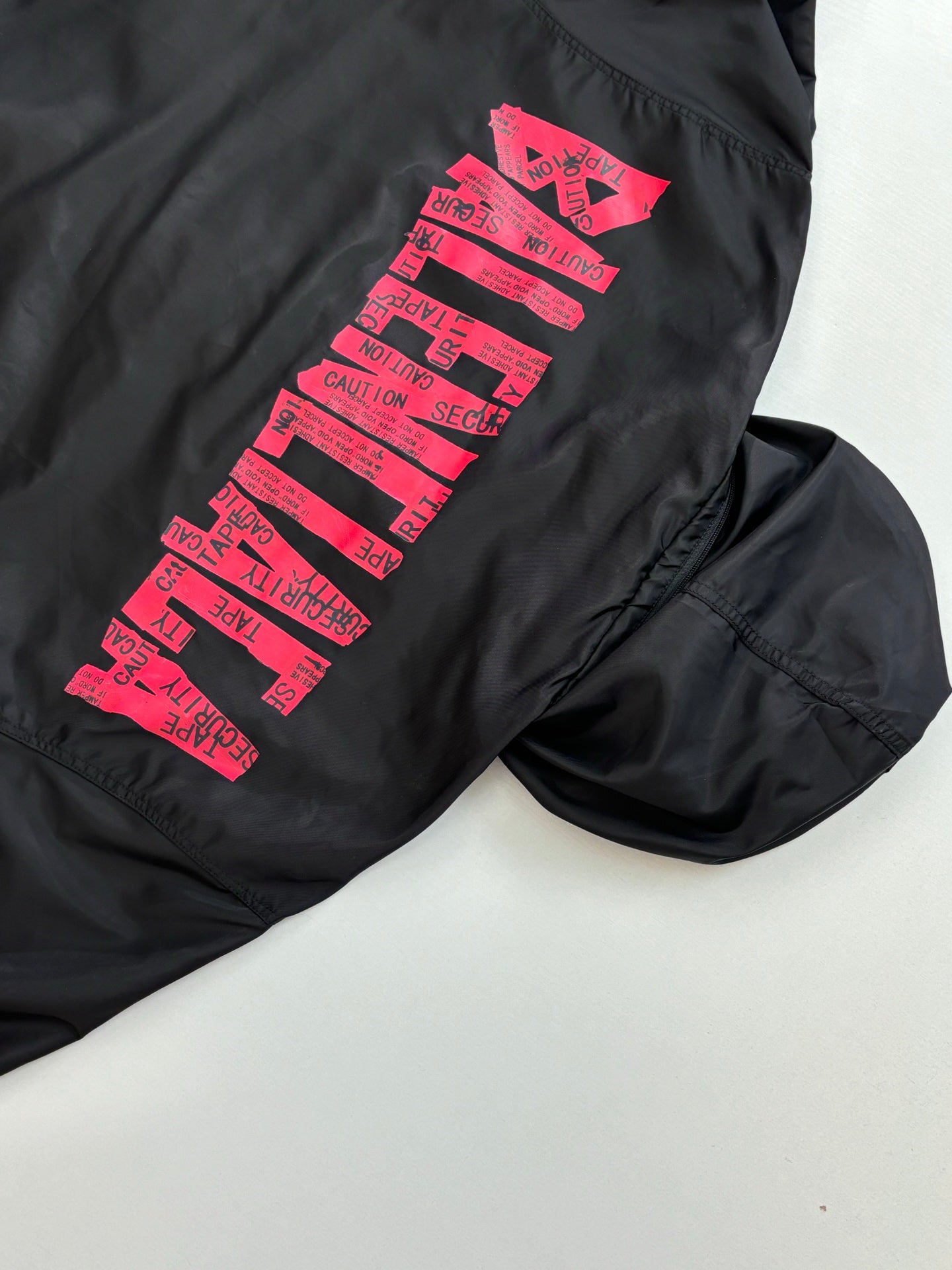 Balenciaga long-sleeve jacket, black with pink logo graphic on sleeve