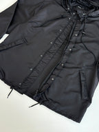Black parka jacket with drawstring hood and buttoned front placket