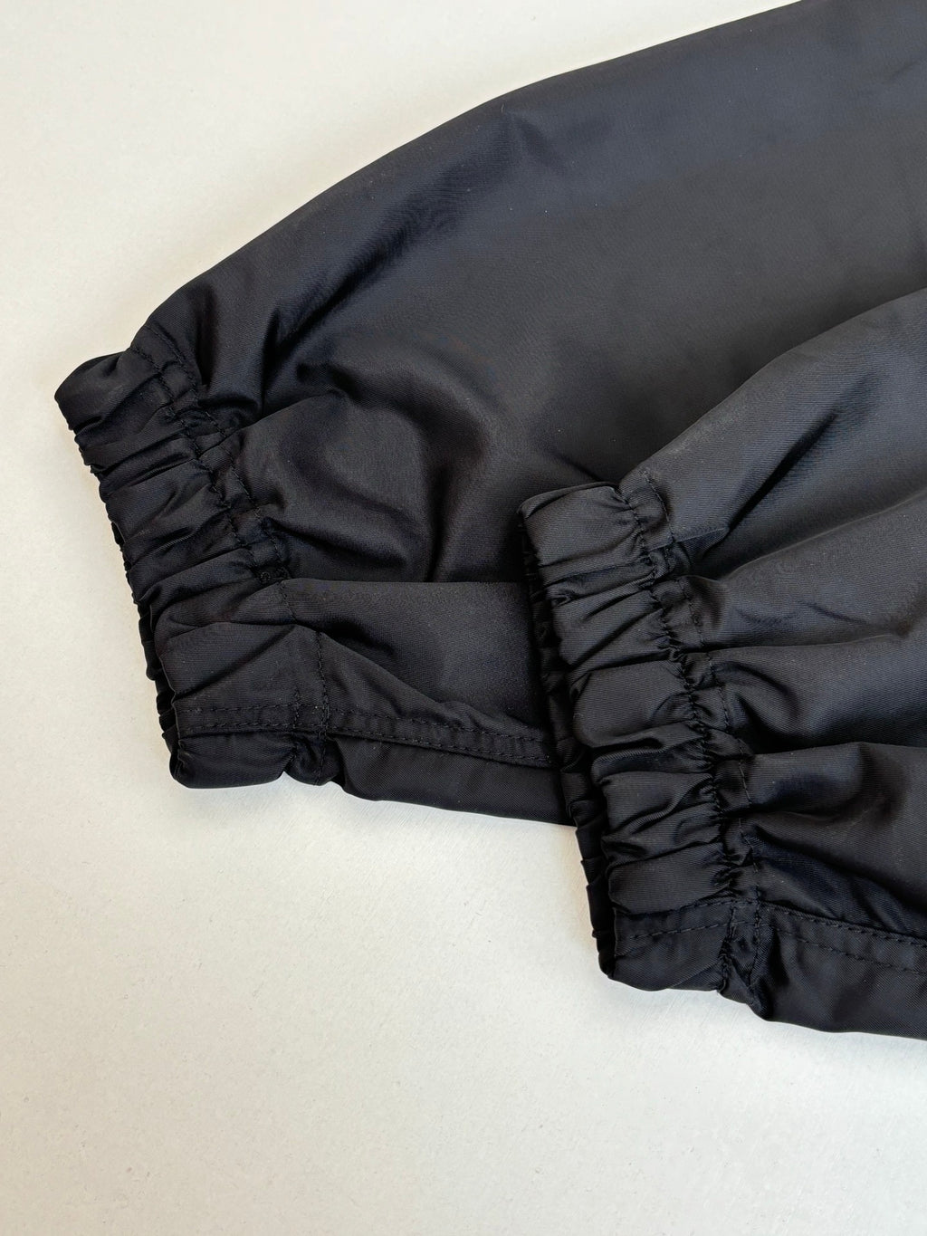 Black parka jacket hem and cuff detail with gathered stitching