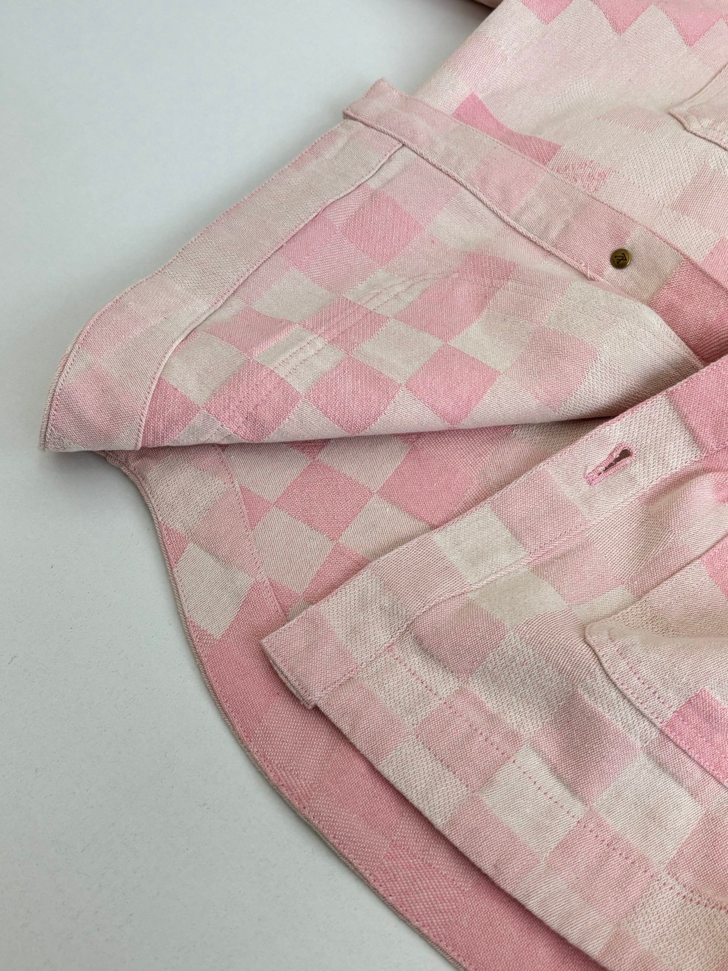 Pink hooded jacket folded with check pattern and buttoned front placket