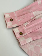 Pink check-pattern jacket cuffs with gold buttons and stitched hems
