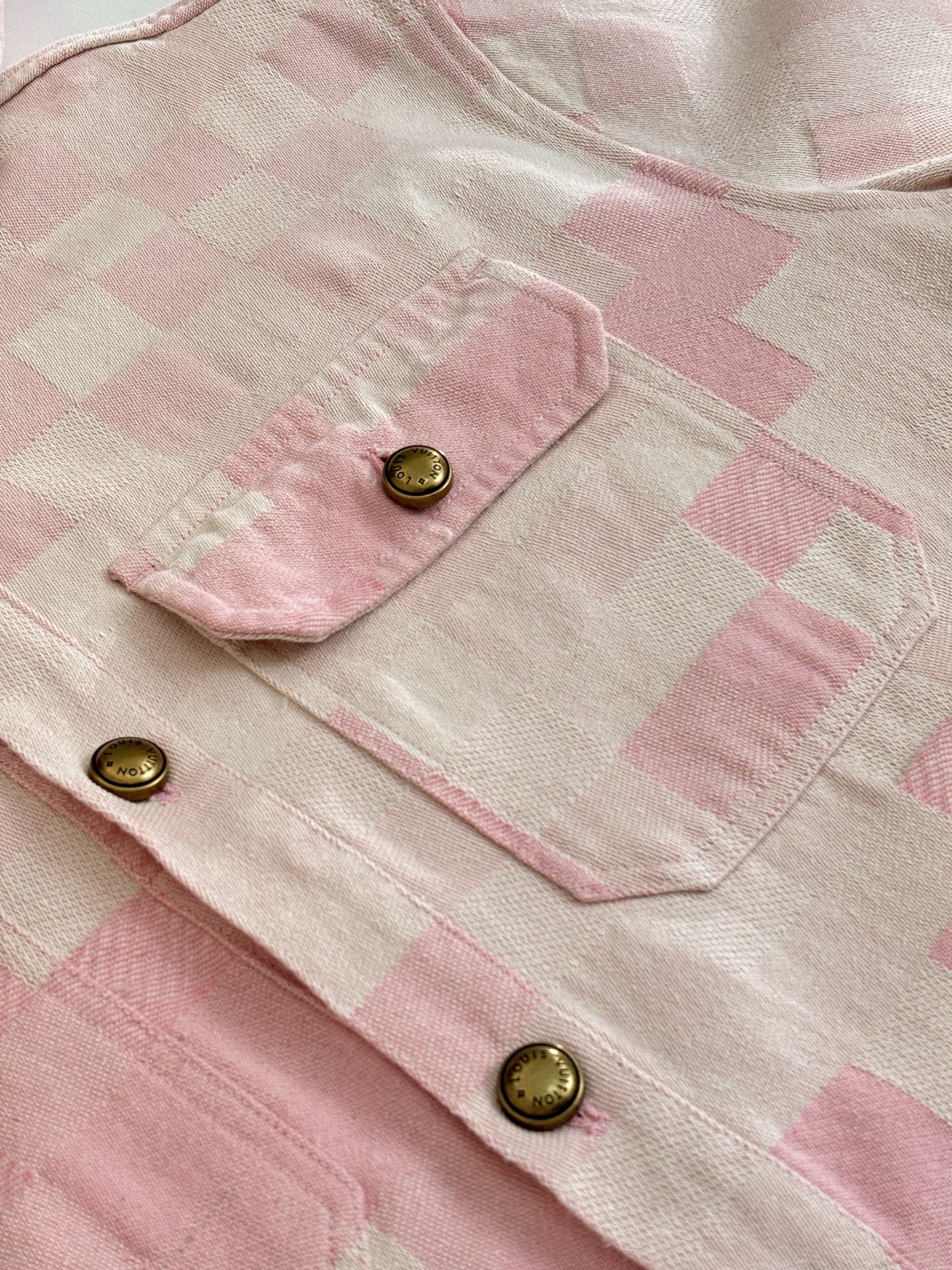 Pink check-pattern jacket sleeve and cuffs with gold button closures