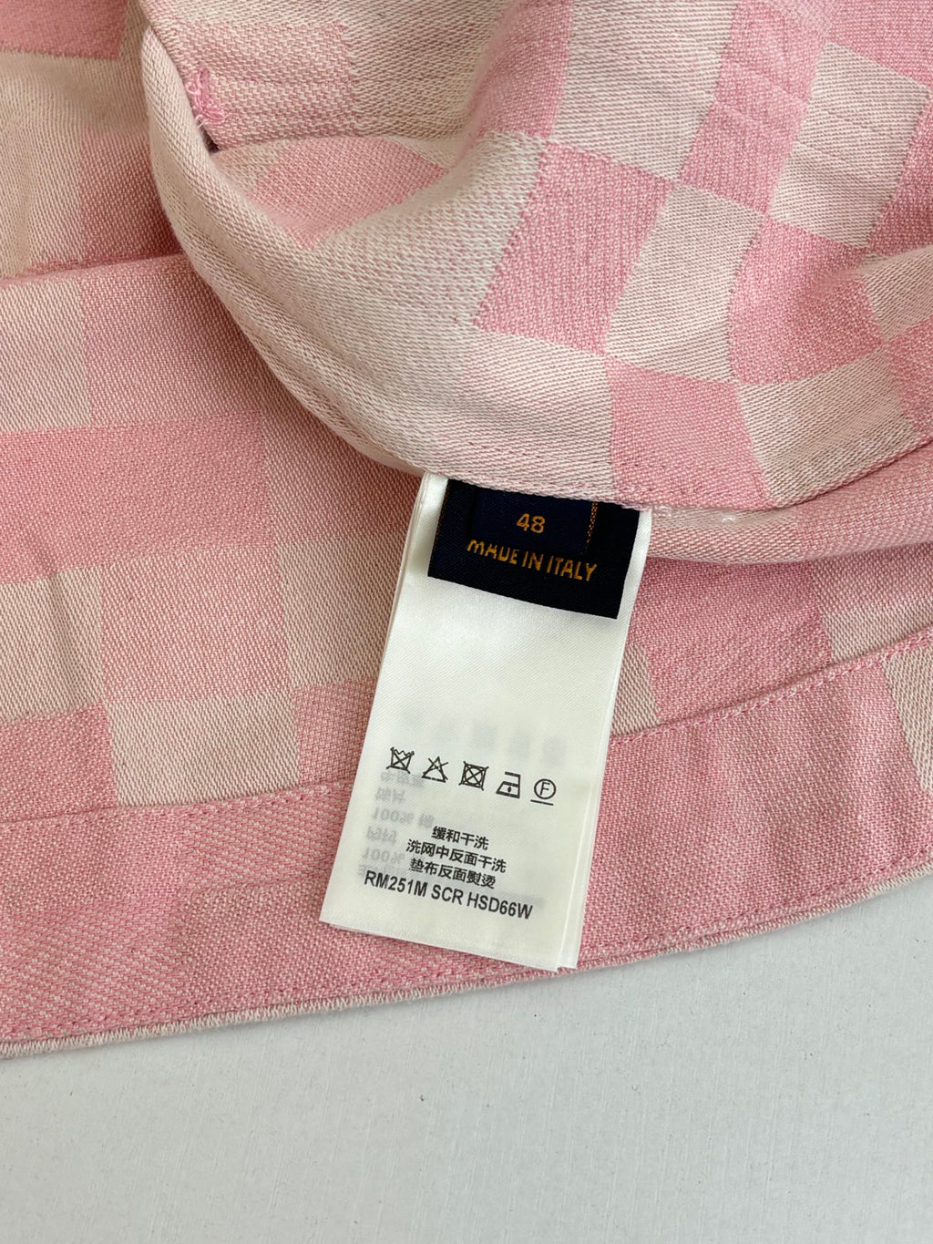 Care and size label on pink hooded jacket with patchwork check fabric