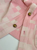 Pink hooded jacket shoulder and chest detail with gold buttons and check pattern