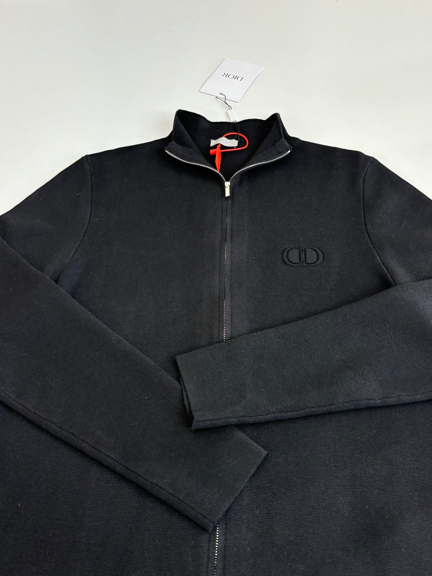 Dior long-sleeve zip jacket detail, black fabric with chest logo