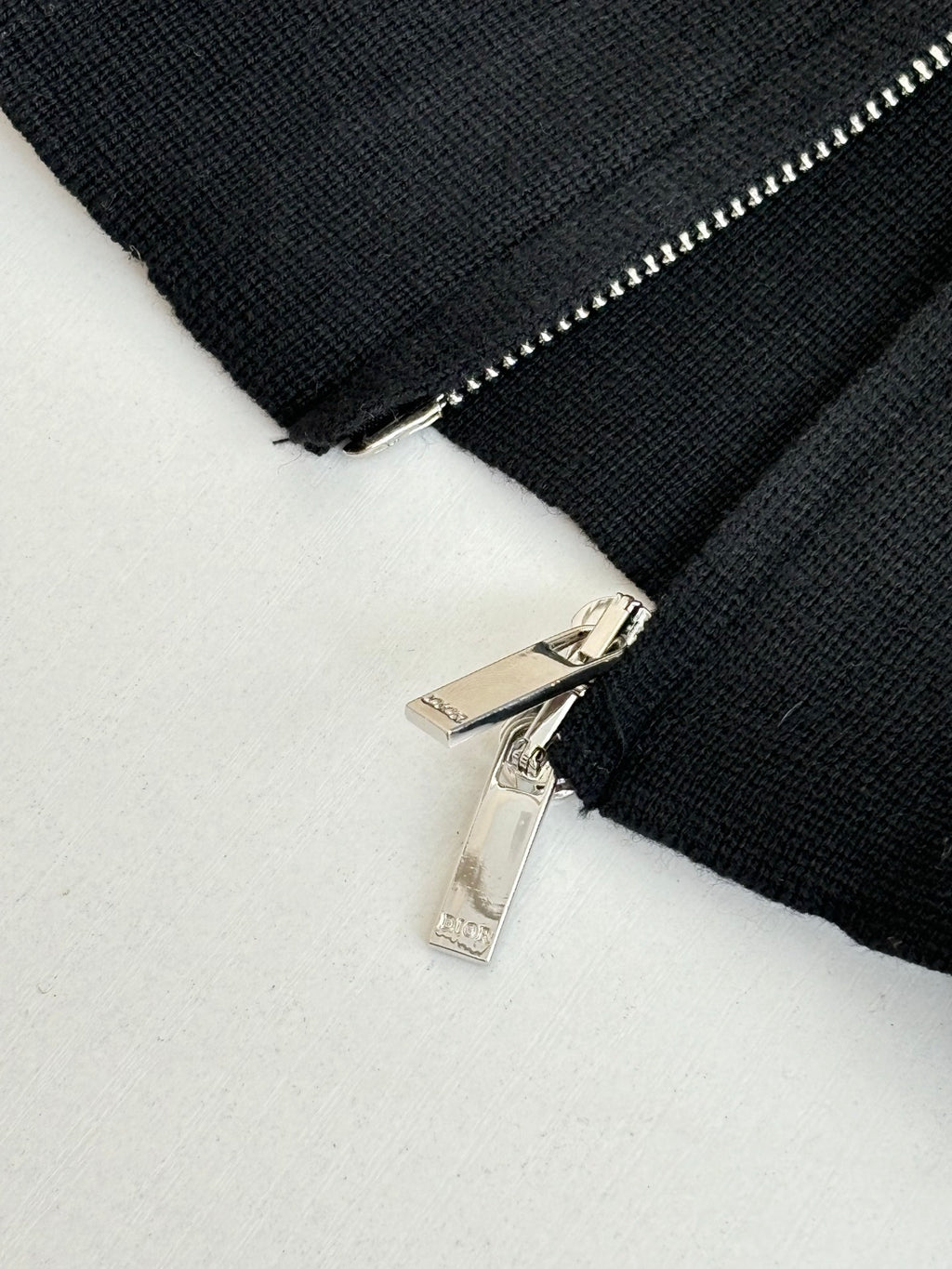 Black zip jacket detail with silver zipper pull and teeth