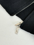 Black zip jacket detail with silver zipper pull and teeth
