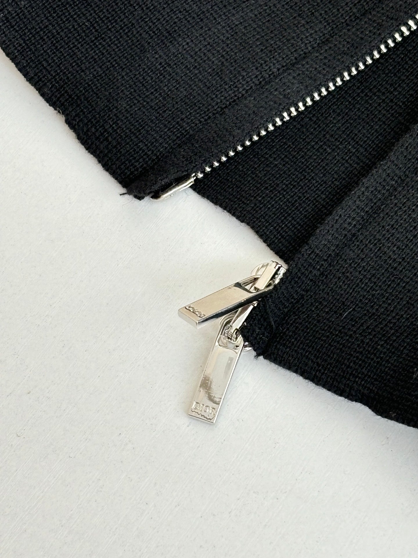 Black zip jacket detail with silver zipper pull and teeth