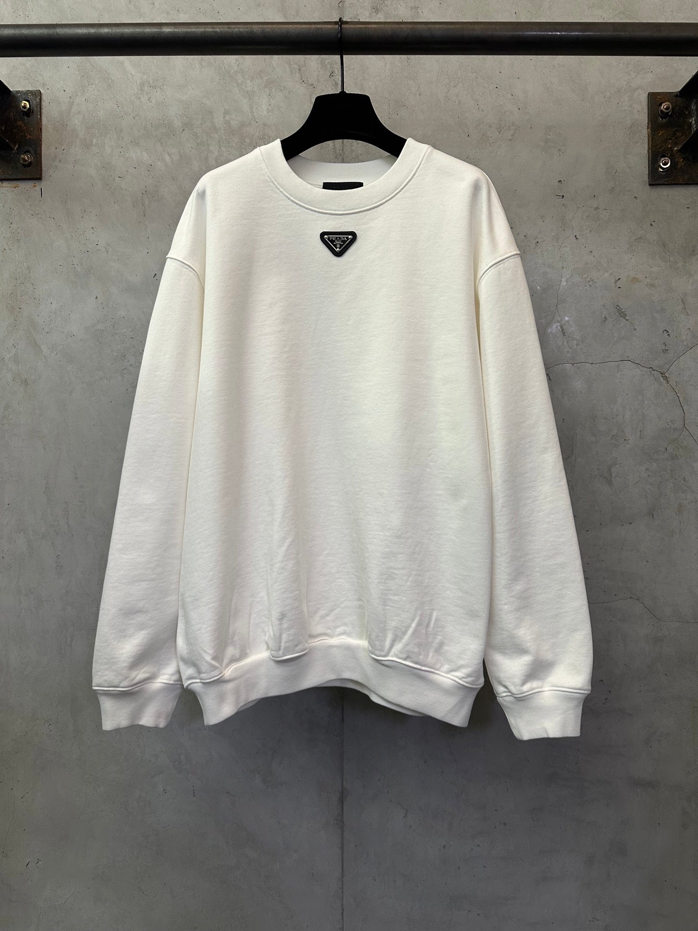 White long-sleeve sweatshirt with small Prada triangle logo at chest
